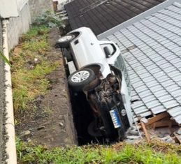 VÍDEO: Carro desgovernado bate em muro e fica lateralizado sobre telhado de casa em Chapecó